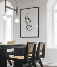 Load image into Gallery viewer, Line art style print artwork hanging in a dining room with a black line illustrating a seated woman with towel on her head.
